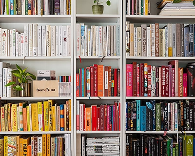 Bookshelf full of books organized by different colors. Making Sense of UX Research