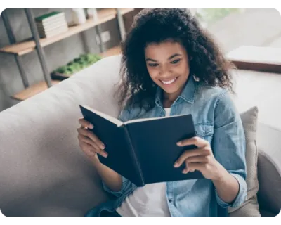 A woman reading and smiling because she found the user experience information she wanted from the userlytics blog posts